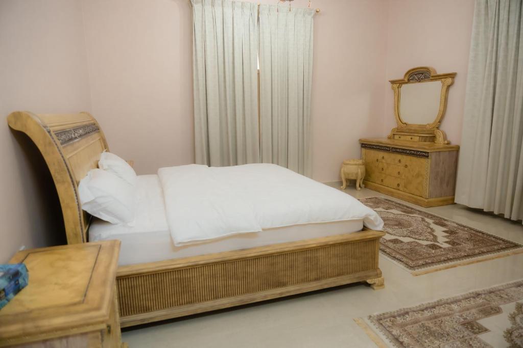 a bedroom with a bed and a mirror and a chair at Alnessayem Farmhouse in Sayḩ aş Şaqlah