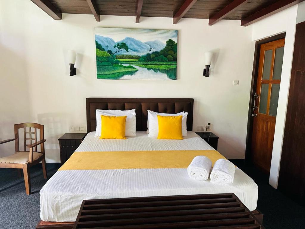 sypialnia z dużym łóżkiem z żółtymi poduszkami w obiekcie Elegant Hamlets Home Stay w mieście Chilaw
