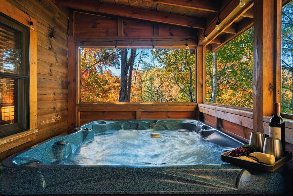 a jacuzzi tub in a cabin with a window at Dreamside Peak in Pigeon Forge
