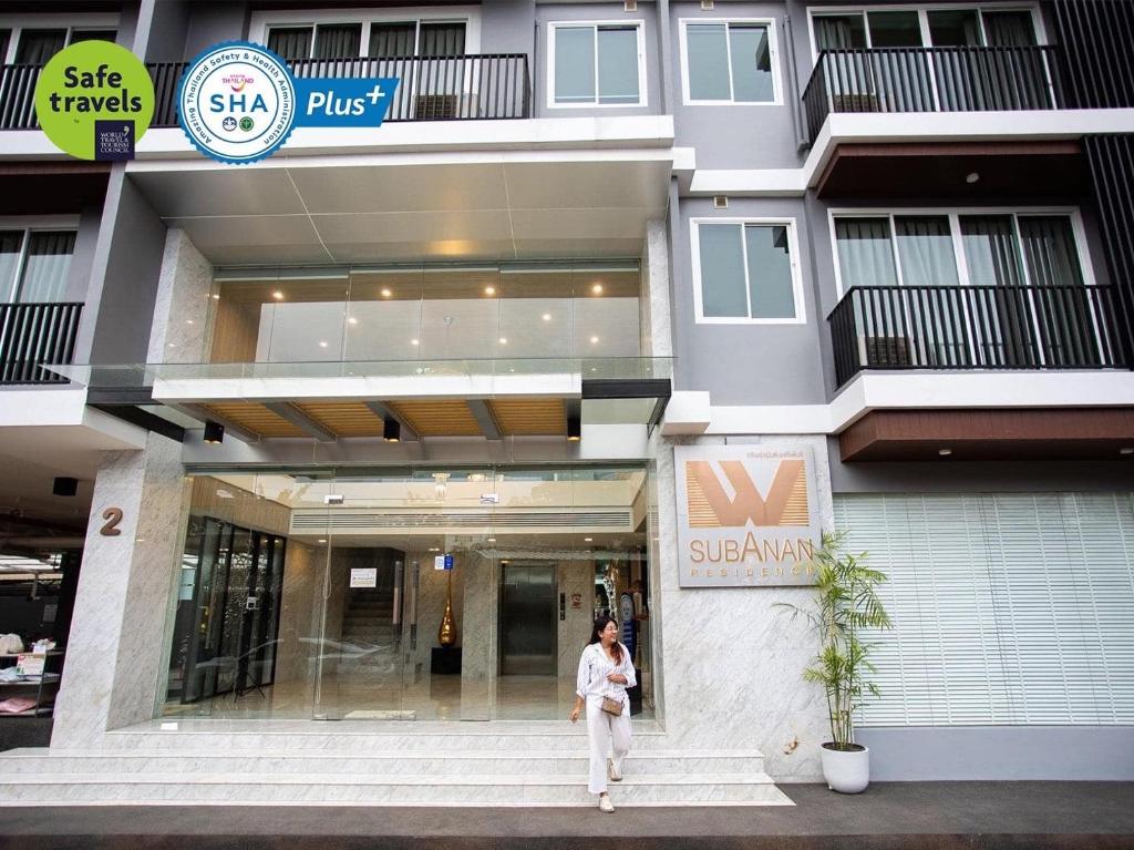 a woman standing in front of a building at SUBANAN Residence - SHA Extra Plus Certified in Ban Kohong