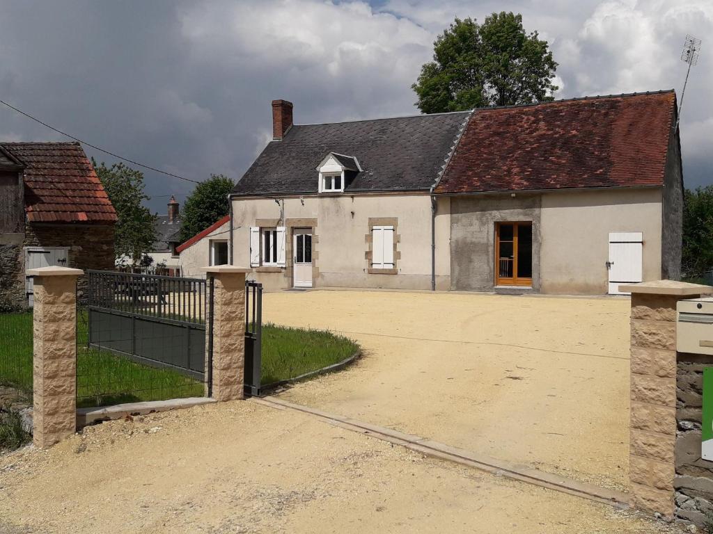 Biały dom z bramą przed nim w obiekcie Gîte Crozon-sur-Vauvre, 5 pièces, 10 personnes - FR-1-591-381 w mieście Crozon-sur-Vauvre
