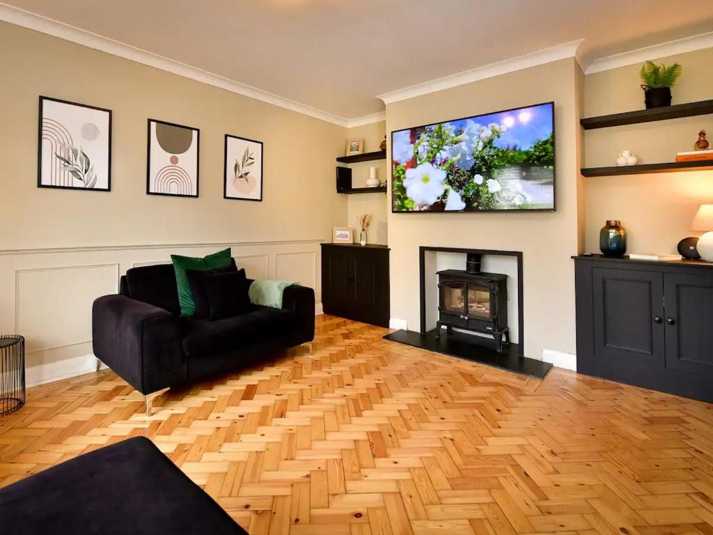 ein Wohnzimmer mit einem TV, einem Sofa und einem Kamin in der Unterkunft Pass the Keys Classy house in Llanishen in Cardiff