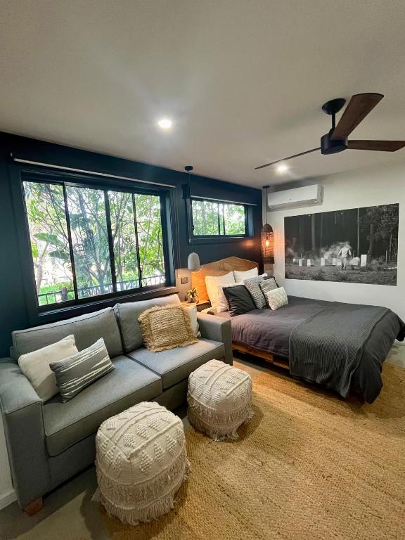 a living room with a bed and a couch at Sunnyside Studio - Pet Friendly Luxury Escape in Port Macquarie