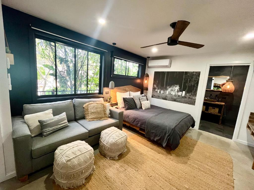 ein Wohnzimmer mit einem Sofa und einem Bett in der Unterkunft Sunnyside Studio - Pet Friendly Luxury Escape in Port Macquarie