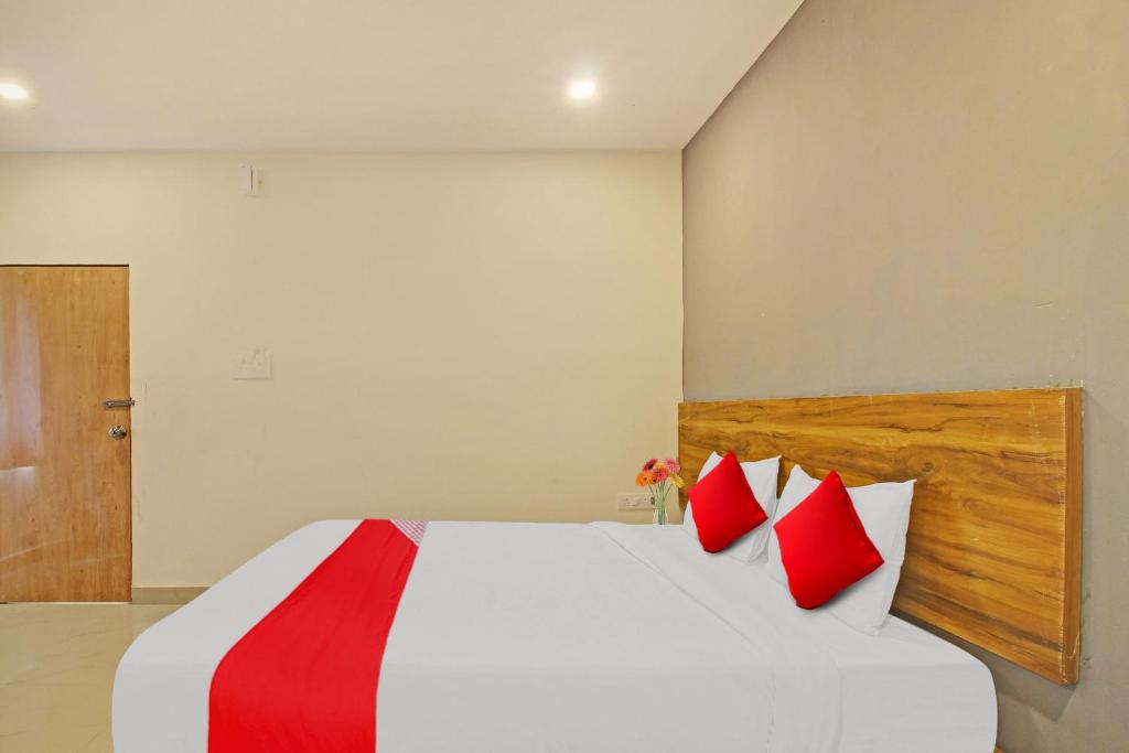 a bedroom with a white bed with red pillows at Flagship Hotel R Square in Warangal