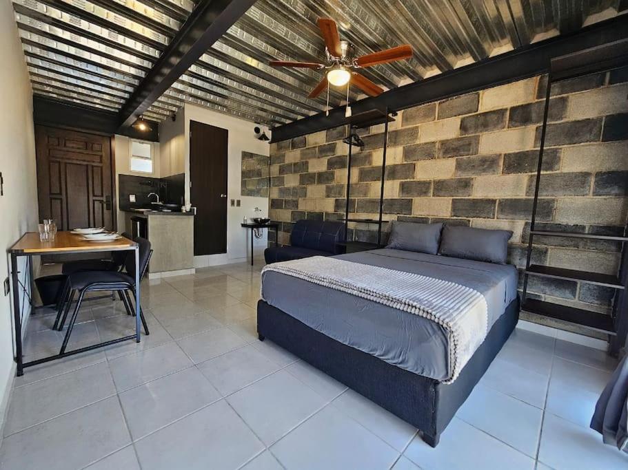 a bedroom with a bed and a brick wall at Depas MiniLoft in Guadalajara
