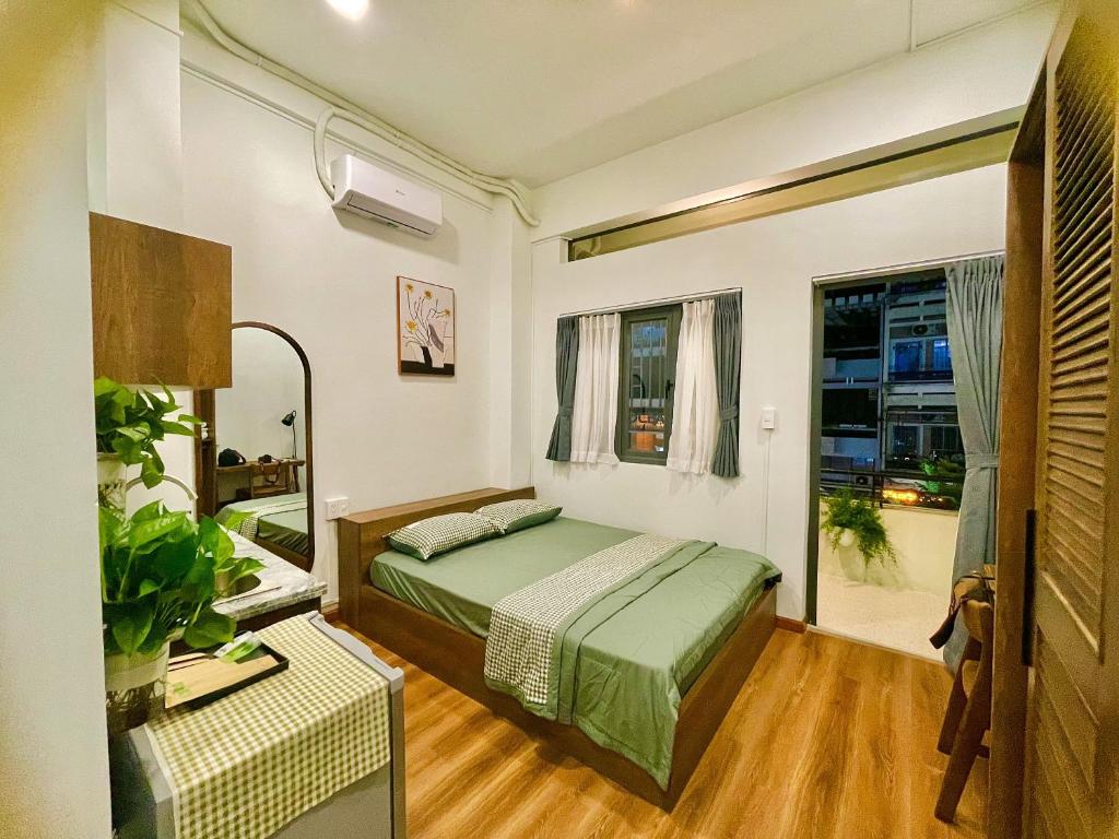 una camera da letto con un letto verde e una finestra di Larita Saigon ad Ho Chi Minh