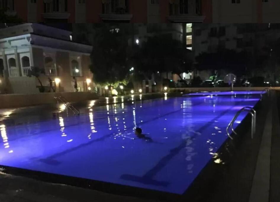 a person swimming in a pool at night at Chateau Elysee A22 near bar resto mall Airport in Manila