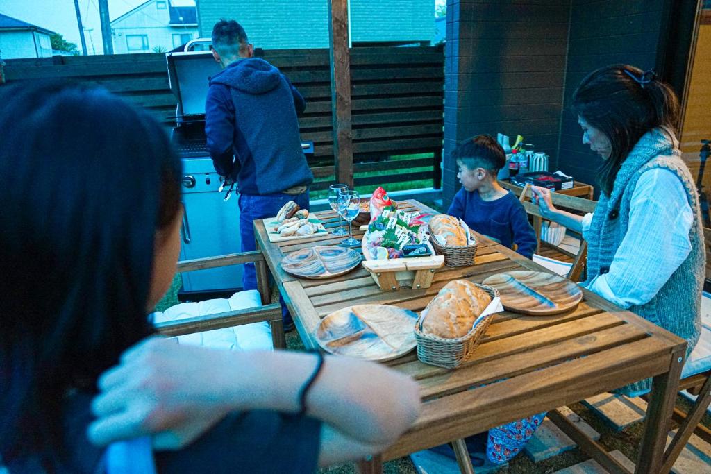 a group of people sitting around a table with food at TAITO BEACH HOUSE in Ichigaya