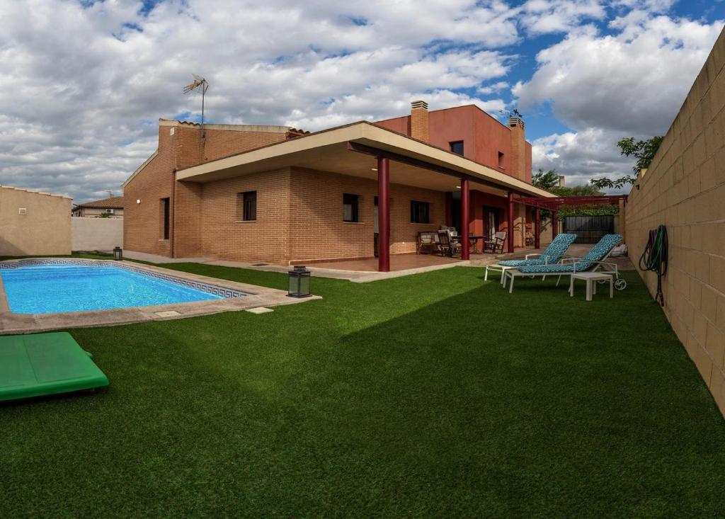 un patio trasero con piscina y un edificio en Casa Miragredos, a solo 5 min de Puy du Fou y Toledo, en Cobisa