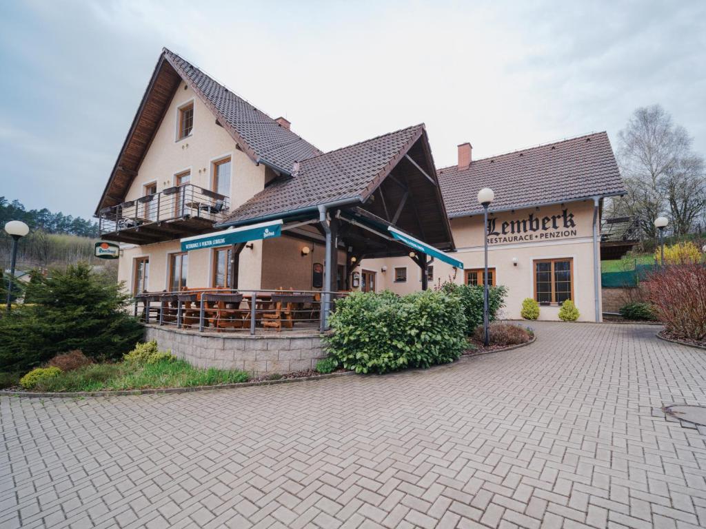 a building with a restaurant on a brick driveway at Penzion a restaurace Lemberk in Jablonné v Podještědí