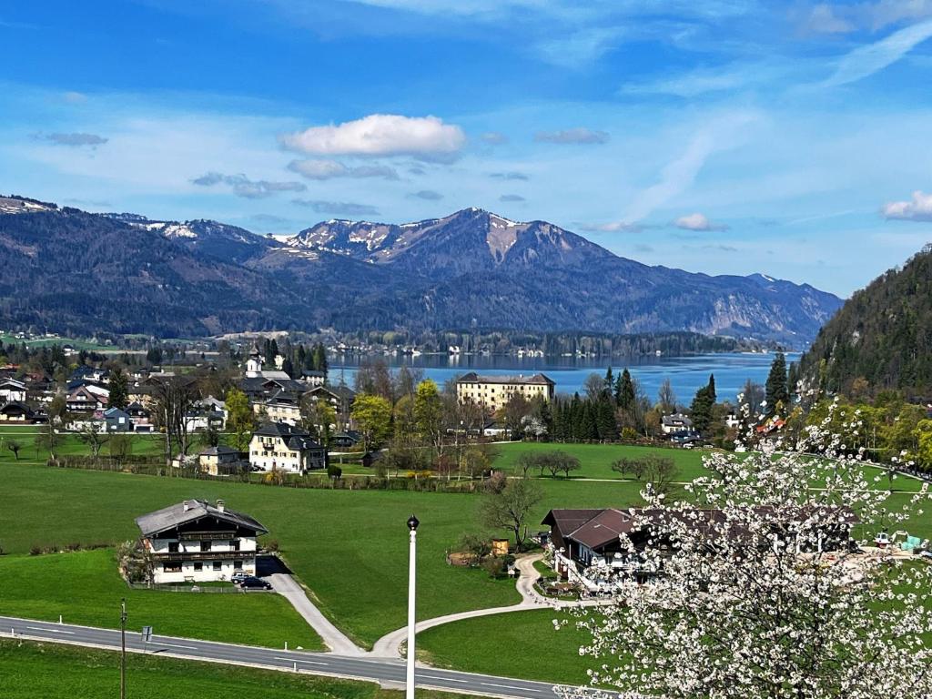a town with a lake and mountains in the background at Wolfgangsee Seeblickplatzl in Strobl