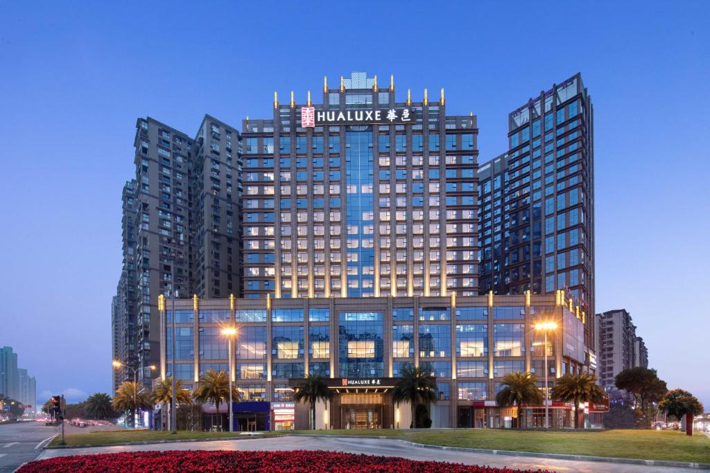 a large building with a sign on top of it at HUALUXE Leshan, an IHG Hotel in Leshan