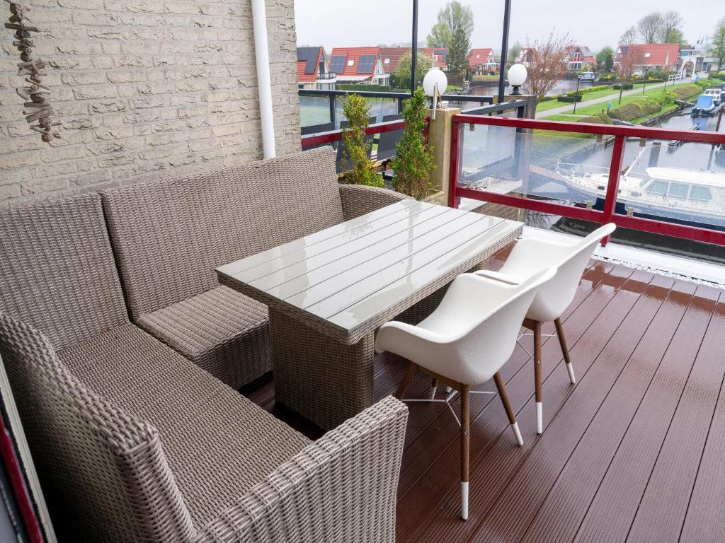 balcón con vistas, mesa de patio y sillas en Cozy Holiday Home in Hasselt Near By The Water, en Hasselt