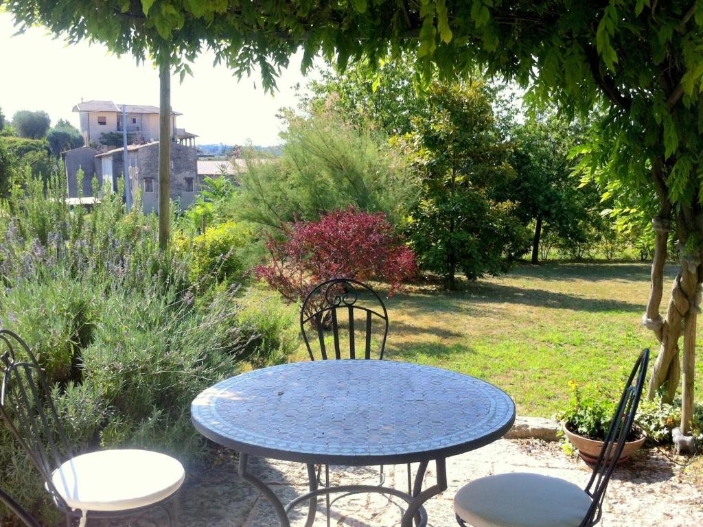 een blauwe tafel en stoelen in een tuin bij Chalet with garden, terrace and barbecue in Pastrengo