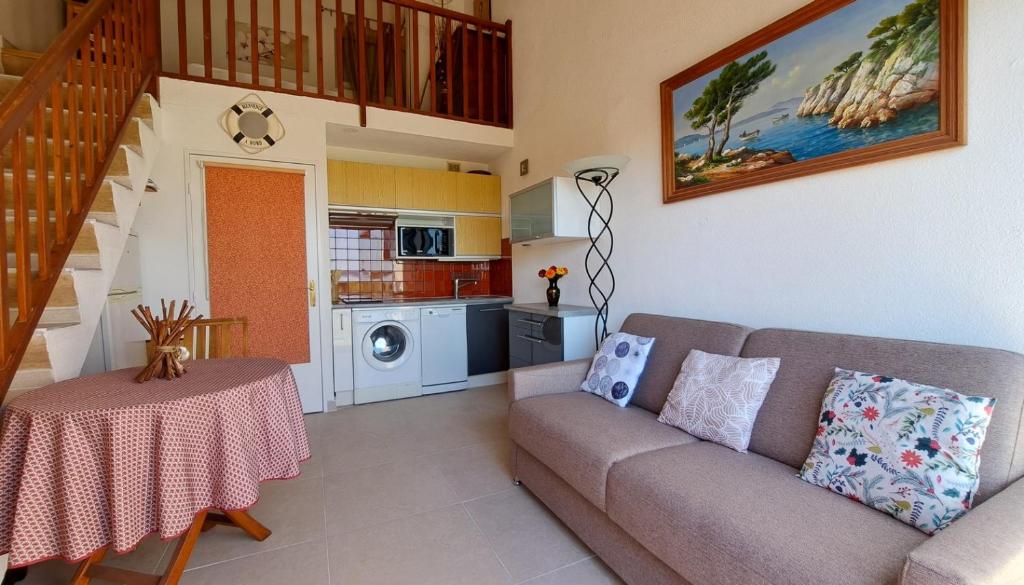 un salon avec un canapé et une table dans l'établissement T2 ensoleillé, vue mer et champ, climatisé, à Carqueiranne