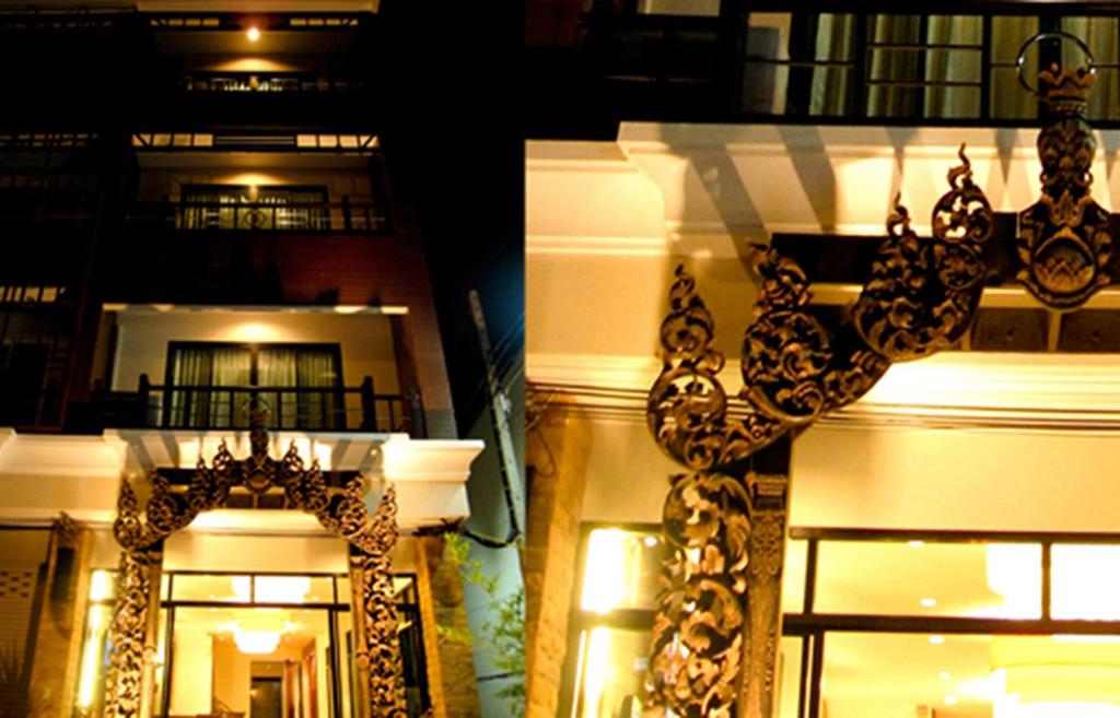 Nicha Suite Hua Hin Hotel في هوا هين: اطلالة على مبنى يوجد امامه ثريا