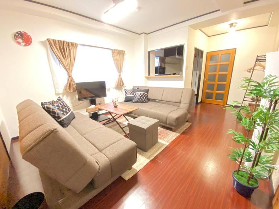 uma sala de estar com um sofá e uma mesa em ファースト天王寺東501 em Osaka