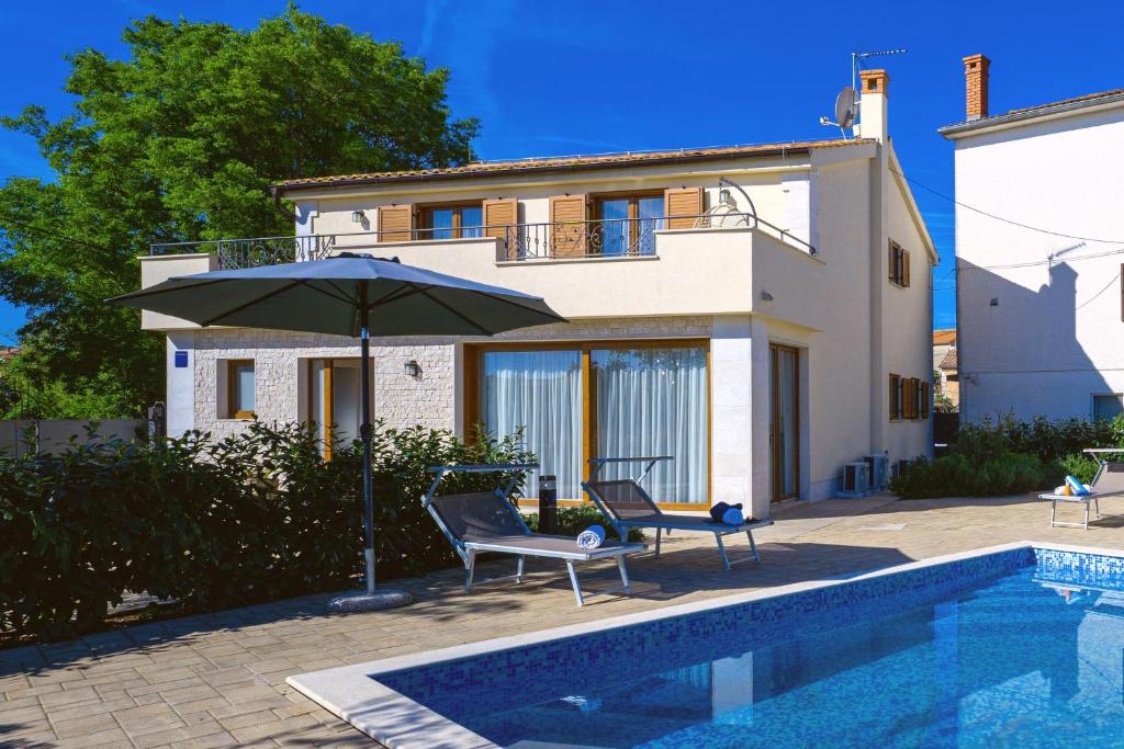 una casa con sombrilla junto a una piscina en Villa Mare With Private Pool And Garden - Happy Rentals, en Sveti Anton