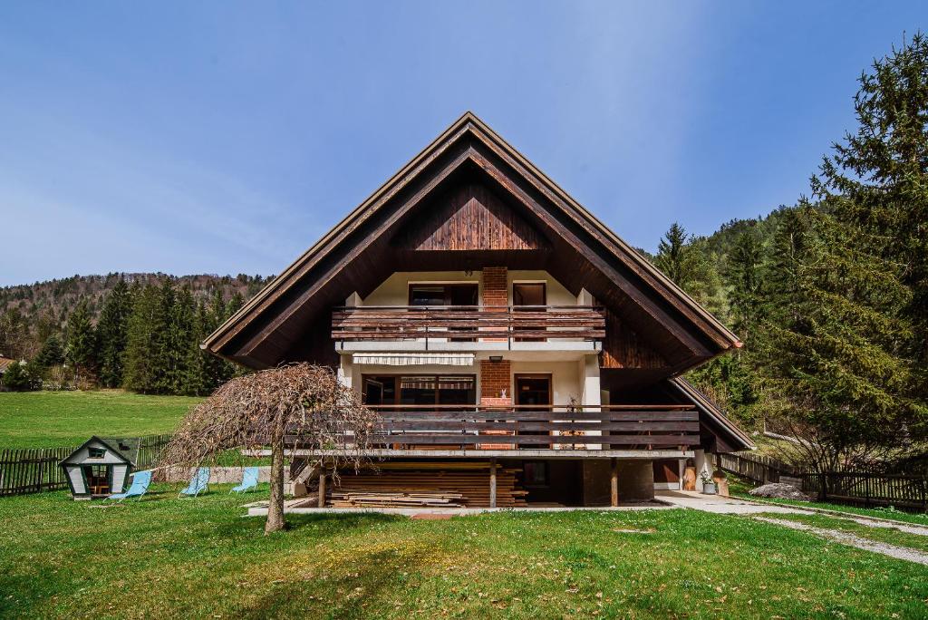a large log house with a gambrel roof at Holiday Home Vila Kopriva in Gozd Martuljek