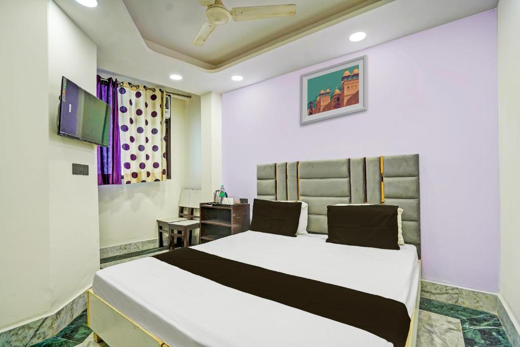 una camera con letto bianco e scrivania di OYO Flagship Starx Inn a Nuova Delhi