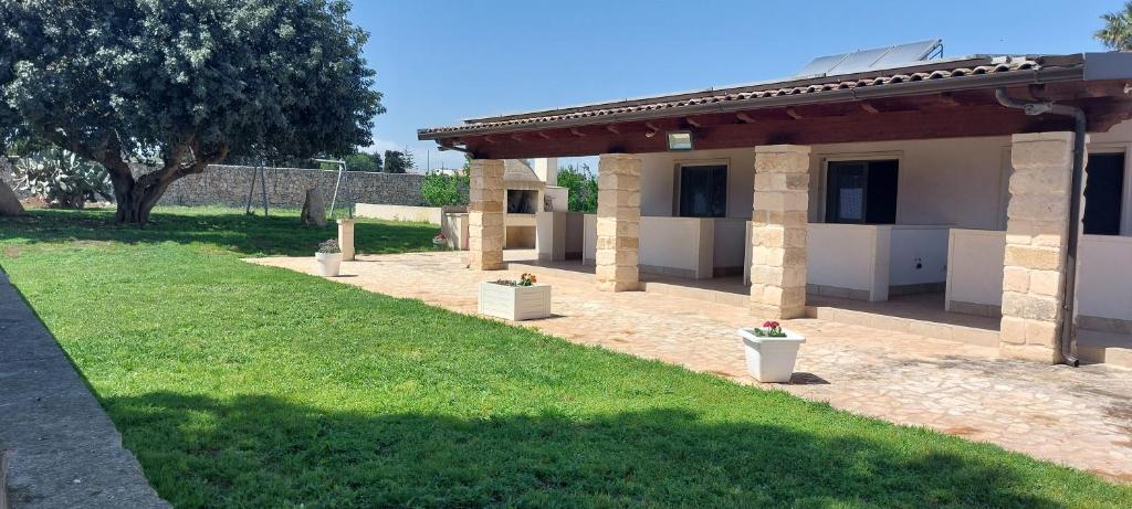 a building with a yard with grass and a building at l'aira ecchia - ospitalità rurale in Lecce