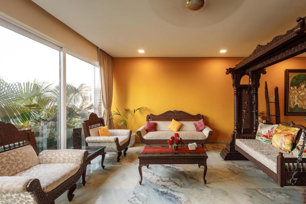 a living room with two couches and a table at JalMahal by JadeCaps Bay View & Pool Dabolim in Vasco Da Gama