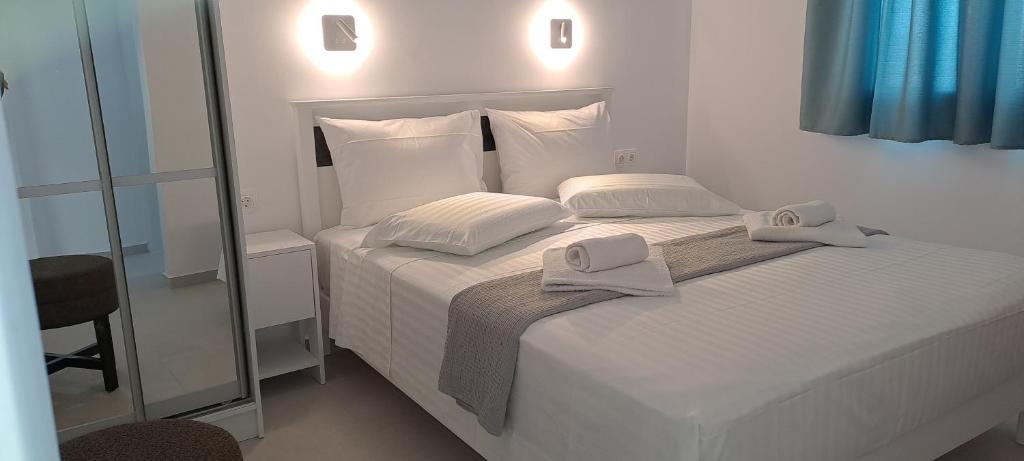 ピソ・リバディにあるDinas Innのベッドルーム1室(白いベッド1台、タオル付)