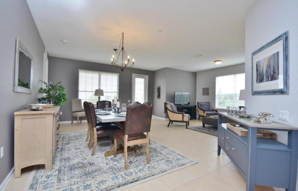 a dining room and living room with a table and chairs at Beautiful Modern Condo, Near Parks-2012 in Orlando