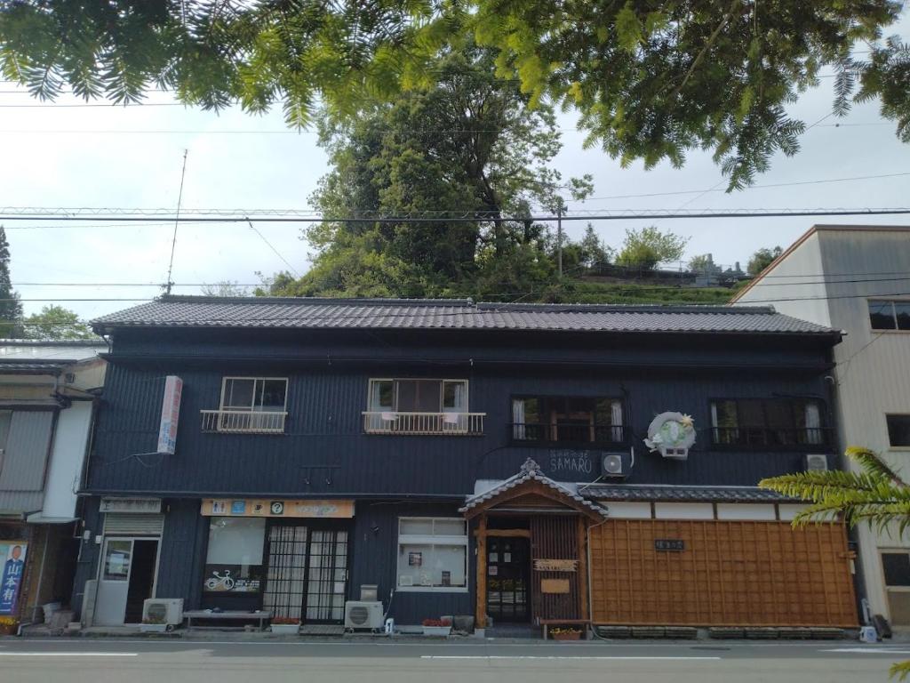 um edifício azul no lado de uma rua em EkimaehouseSamaru em Shimanto-cho