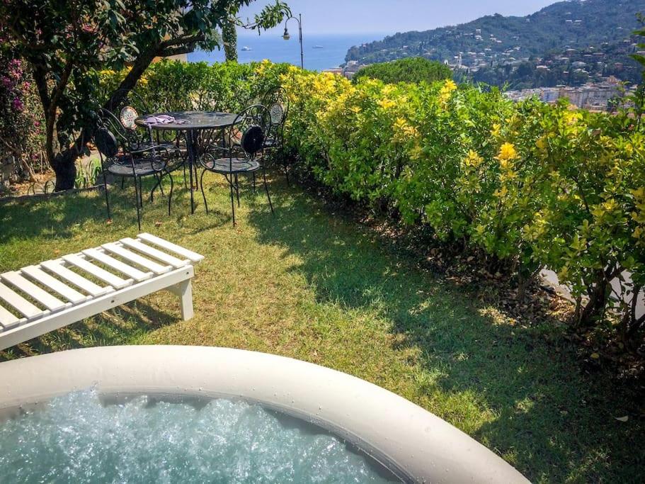 einen Garten mit einem Tisch, einem Tisch und Stühlen in der Unterkunft Dreamy LOFT con vista sul golfo giardino e Jacuzzi in Santa Margherita Ligure
