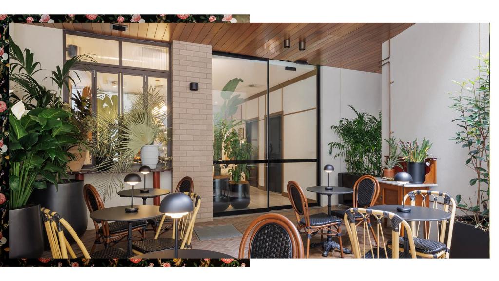un restaurante con mesas, sillas y plantas en 202 Elizabeth Hotel - The Oxford - Australia en Sídney