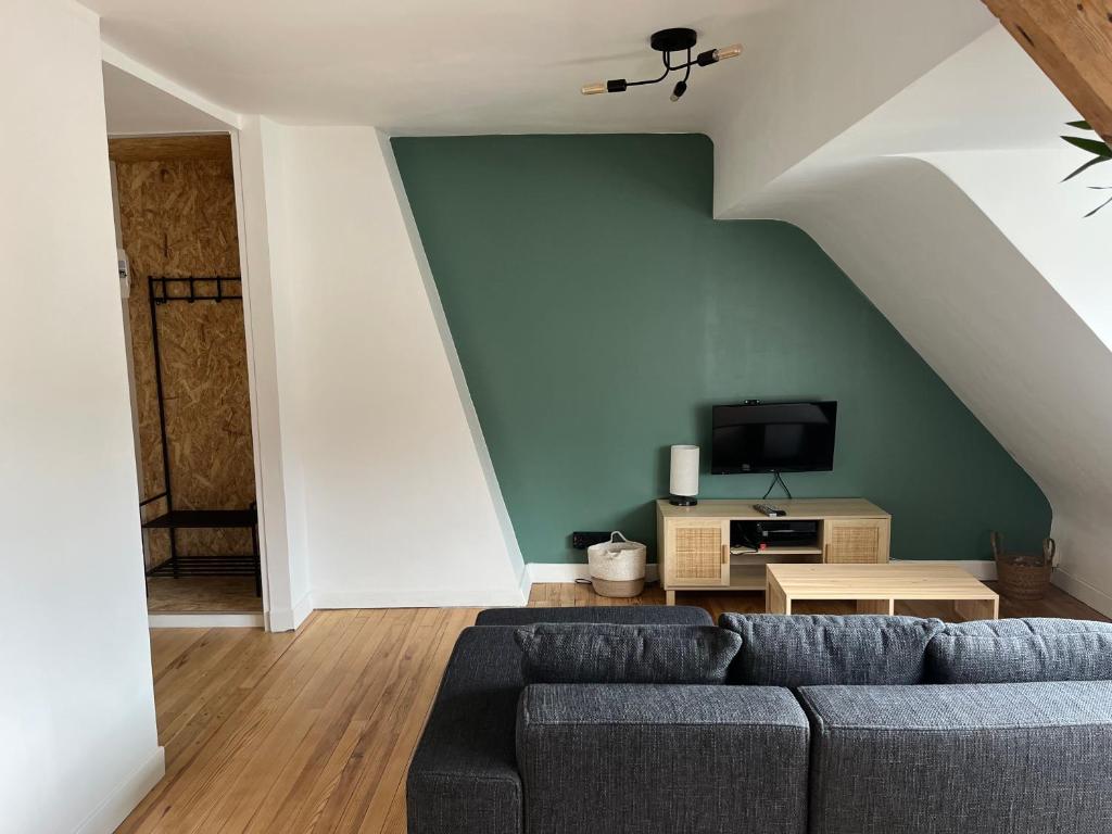 - un salon avec un canapé et une télévision dans l'établissement Appartement rive droite, à Boulogne-sur-Mer