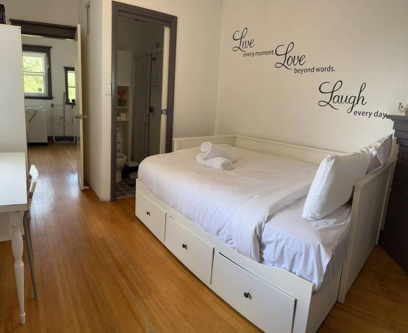 a bedroom with a white bed with a sign on the wall at Budget 1 bedroom unit near Maroubra Beach in Sydney