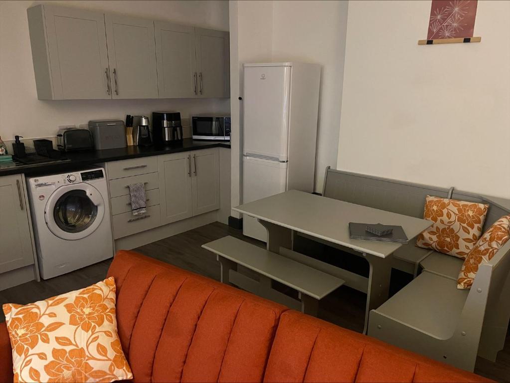 a kitchen with a couch and a table and a refrigerator at Quirky and Cosy Self Contained Flat, Ferryhill Near Durham in Ferryhill