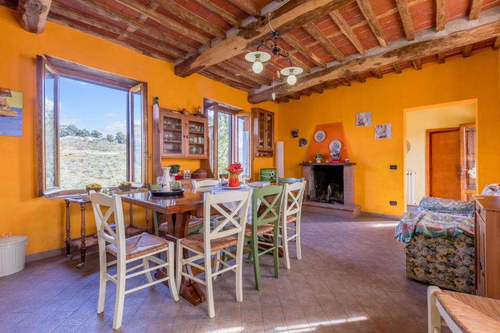 ein Esszimmer mit gelben Wänden sowie einem Tisch und Stühlen in der Unterkunft Casale Geniva with Private Pool - Happy Rentals in Massarosa