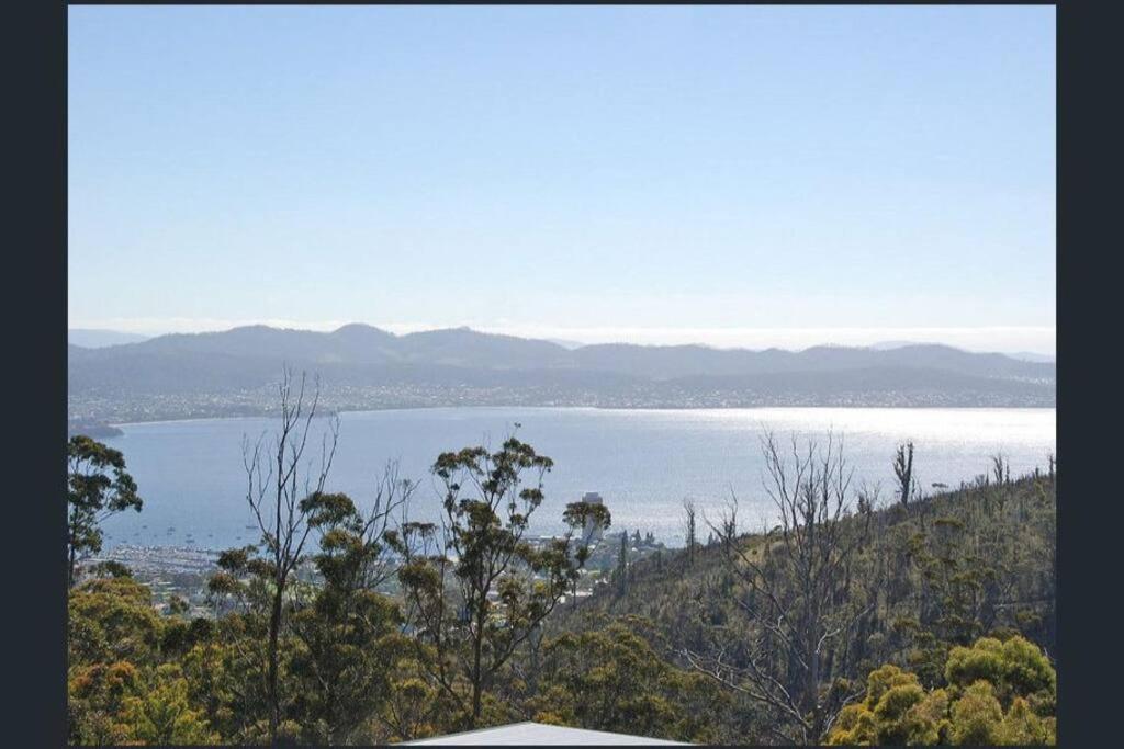 una vista de un cuerpo de agua desde una colina en Modern executive house, stunning views over Hobart, en Sandy Bay
