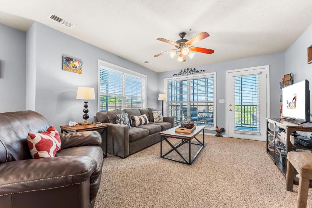 a living room with couches and a ceiling fan at Par View Vista Condo in Branson West