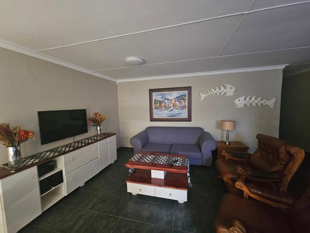 a living room with a purple couch and a tv at Amberdale Estate Self Catering in Queenstown