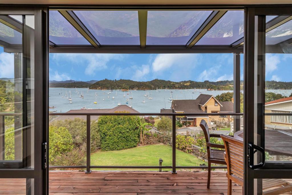 - une vue depuis la fenêtre d'une maison avec des bateaux dans l'eau dans l'établissement Seascape Sanctuary - Okiato Holiday Home, à Russell