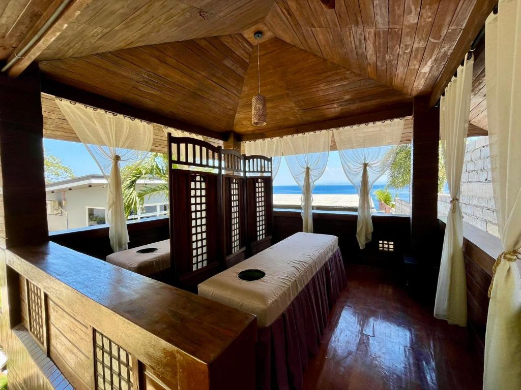 een slaapkamer met een bed en uitzicht op de oceaan bij Porto Novo Anilao Dive and Leisure Resort in Mabini