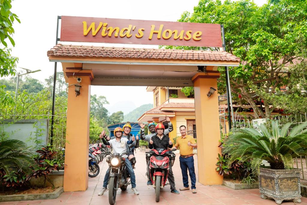 um grupo de pessoas em pé em frente a uma casa de ventos em Wind's House Ha Giang em Ha Giang