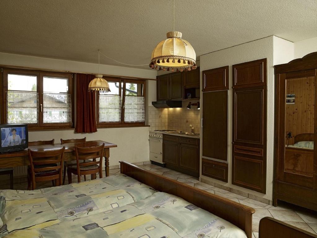 een keuken en eetkamer met een bed in een kamer bij Hôtel-Gîte rural à 3 km de Delémont in Courcelon