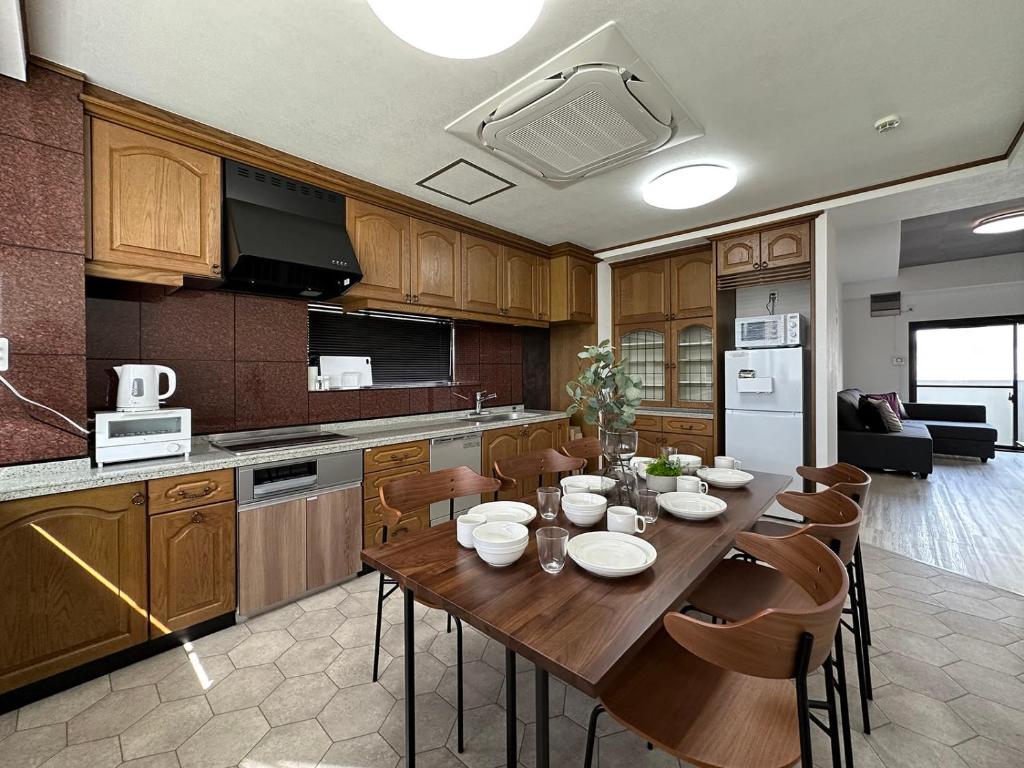 a kitchen with a wooden table and chairs in a kitchen at Luxes - 2Br Apt for 10ppl Very Good Location in Hijiyamachō