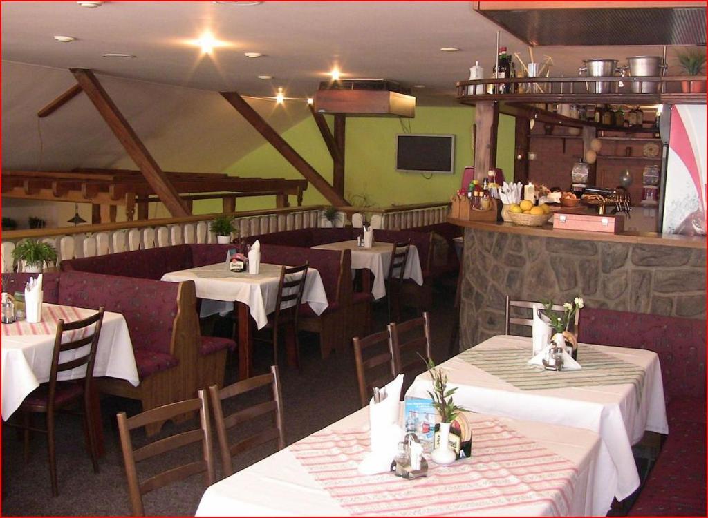 a dining room with tables and chairs with white table cloth at Volarská roubenka in Volary