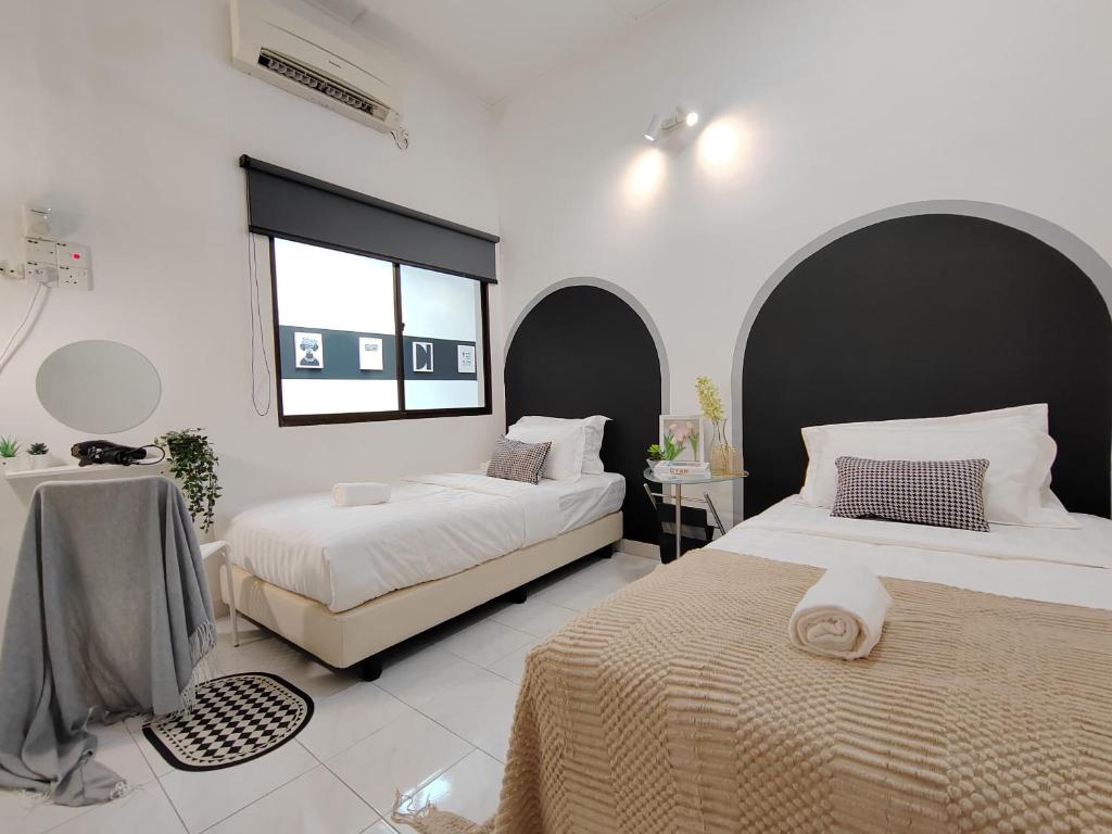 um quarto com 2 camas e uma janela em Sunway Tambun Salesman Stay 5 Bedroom 10pax by IWH em Ipoh