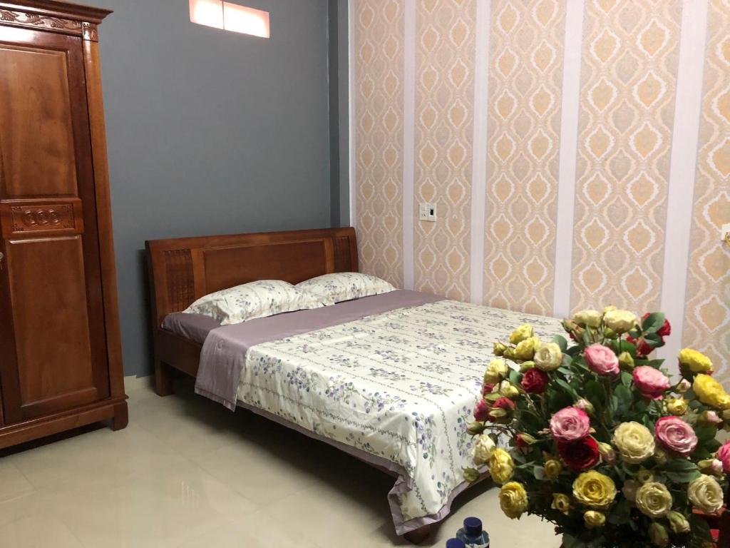 een slaapkamer met een bed en een boeket rozen bij LyLy Homestay in Dien Bien Phu