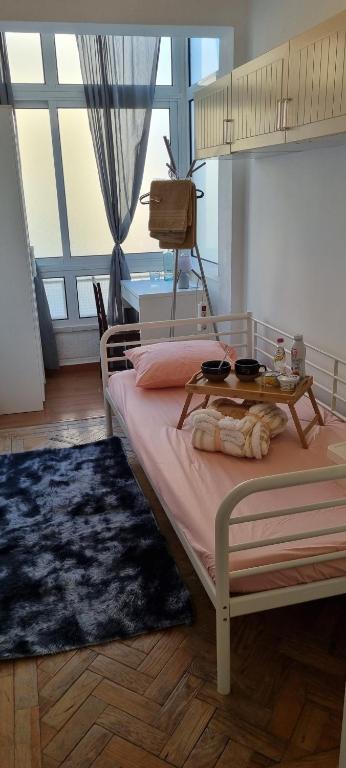 1 dormitorio con 1 cama con mesa y ventana grande en Nivea Soares, en Lisboa