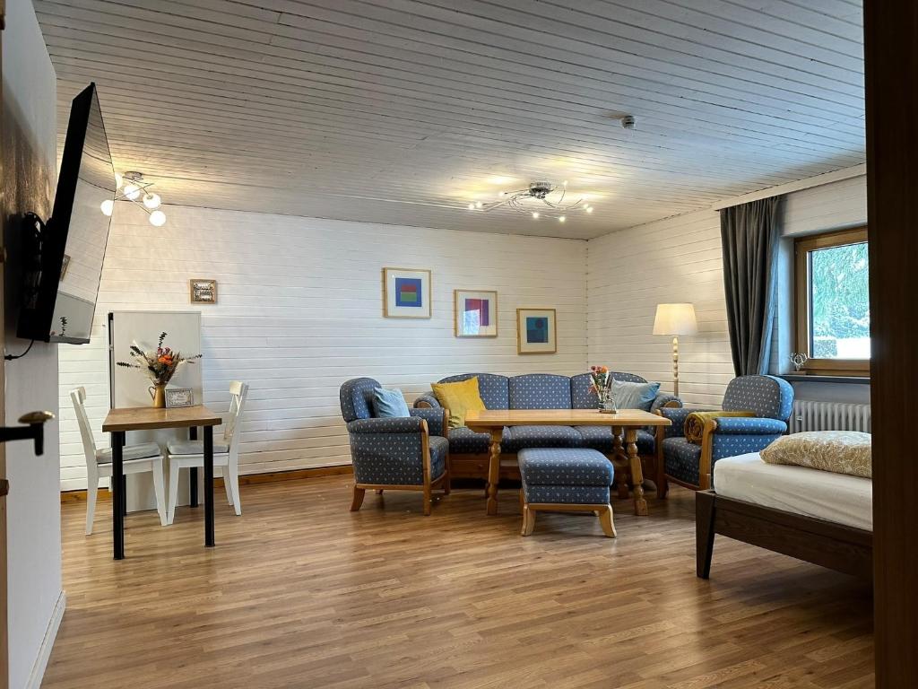 Habitación con sillas, mesa y sofá en Appartement Tegelberg, en Steingaden