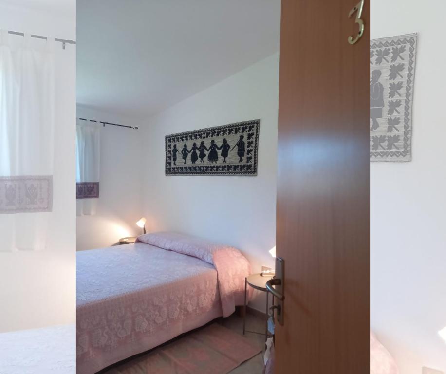 ein Schlafzimmer mit einem Bett in einem Zimmer in der Unterkunft Agriturismo Su Cuile Countryside Comfort Rooms in Budoni